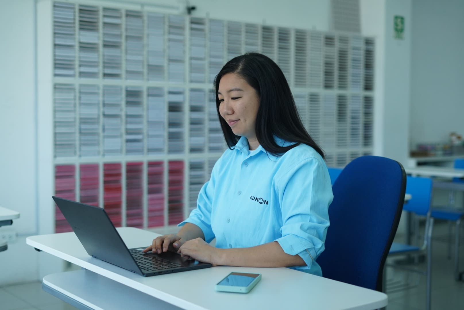 Orientador de Kumon frente a una computadora, participando en una capacitación en línea