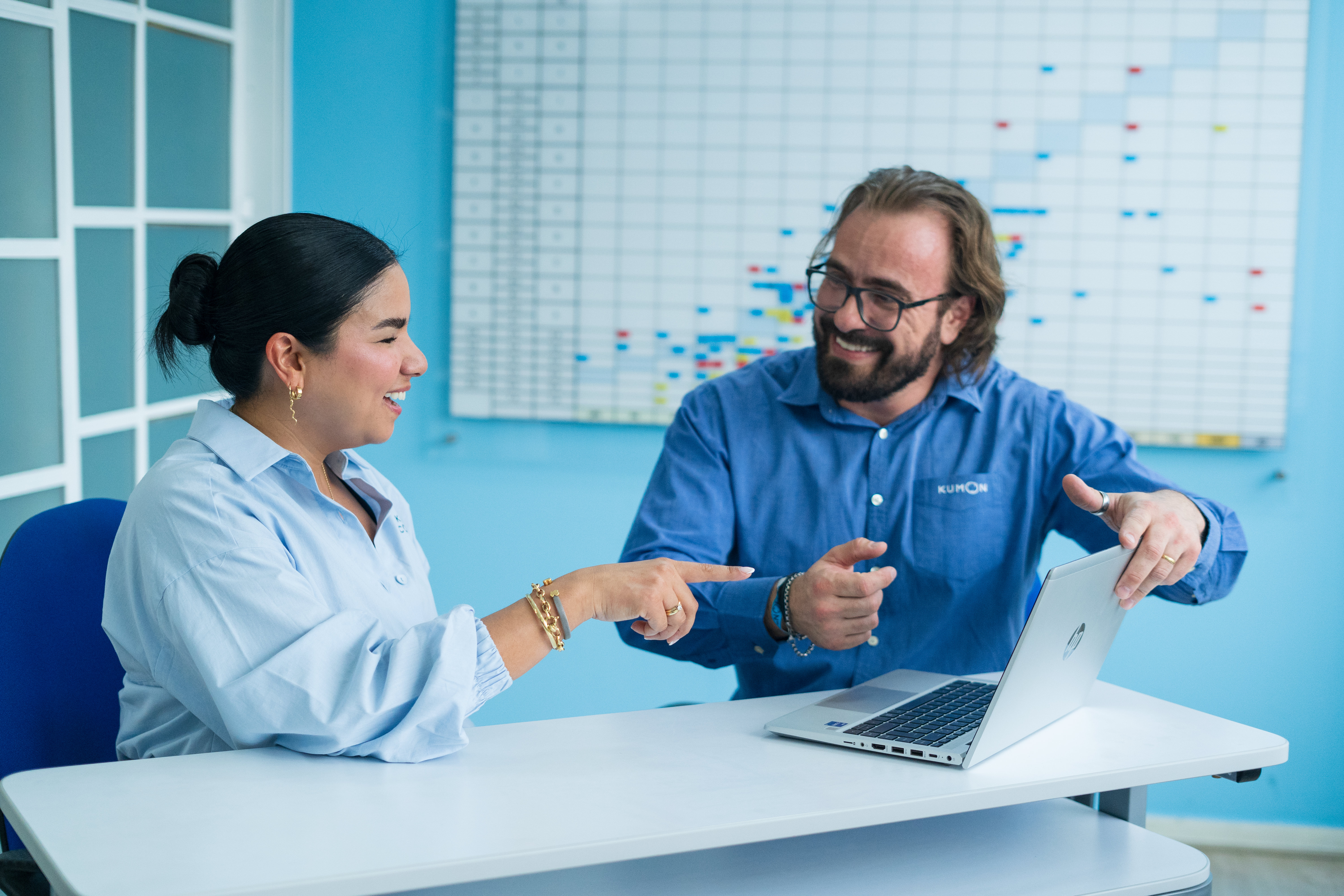 Orientadora y coordinador de Kumon sentados frente a una laptop hablando sobre la franquicia Kumon