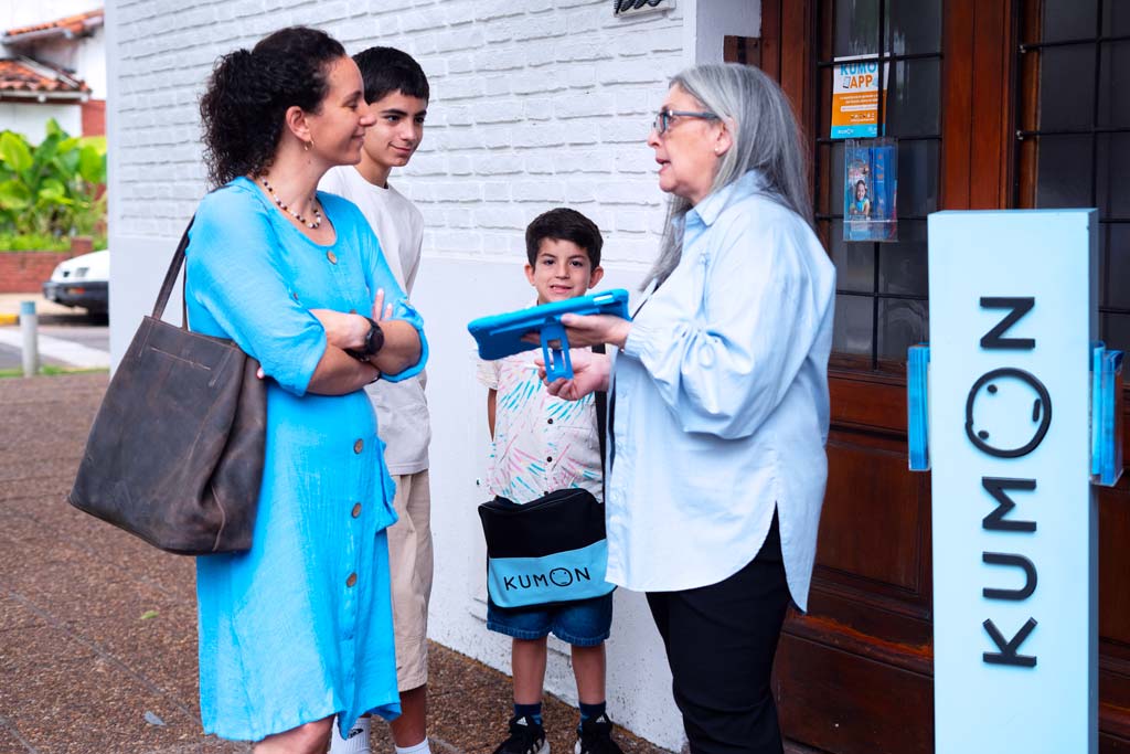 Familia conversando con una orientadora frente a un centro Kumon